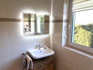 Waschbecken und Spiegel mit Handtuchhalter und Schrank