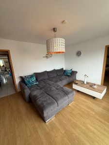 Wohnzimmer mit großem Sofa und Wohnzimmertisch