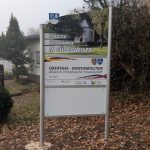 Ortseingangsschild von Güdesweiler, weißes Schild mit Foto der Valentinskapelle ; Herzlich Willkommen in Güdesweiler, Schild, das die deutsch-französische Freundschaft zwischen den Partnergemeinden Oberthal und Moyenmoutier beschreibt. Weiteres weißes Schild.