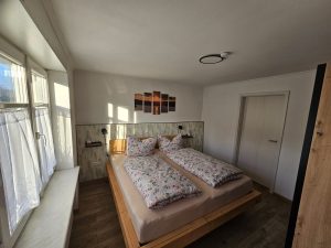 Doppelbett, Fenster, Bilder an der Wand