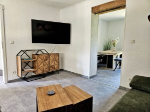 Flachbildschirm, der an der Wand hängt, Durchgang zur Küche